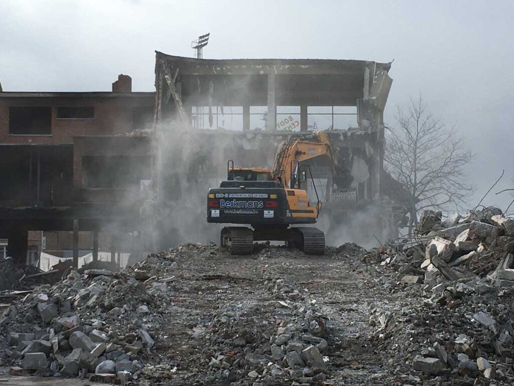 Excavator demolishes building