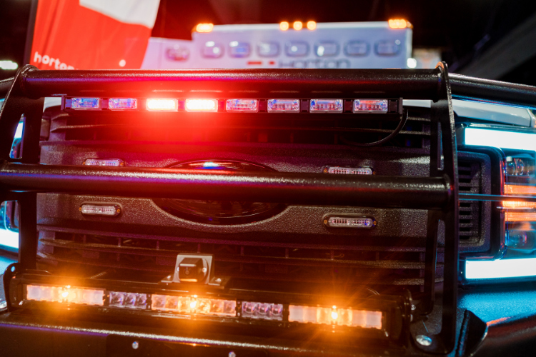 The photo shows the front of an ambulance with its emergency lights on.