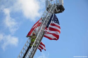 Firefighter on tower ladder with American Flag