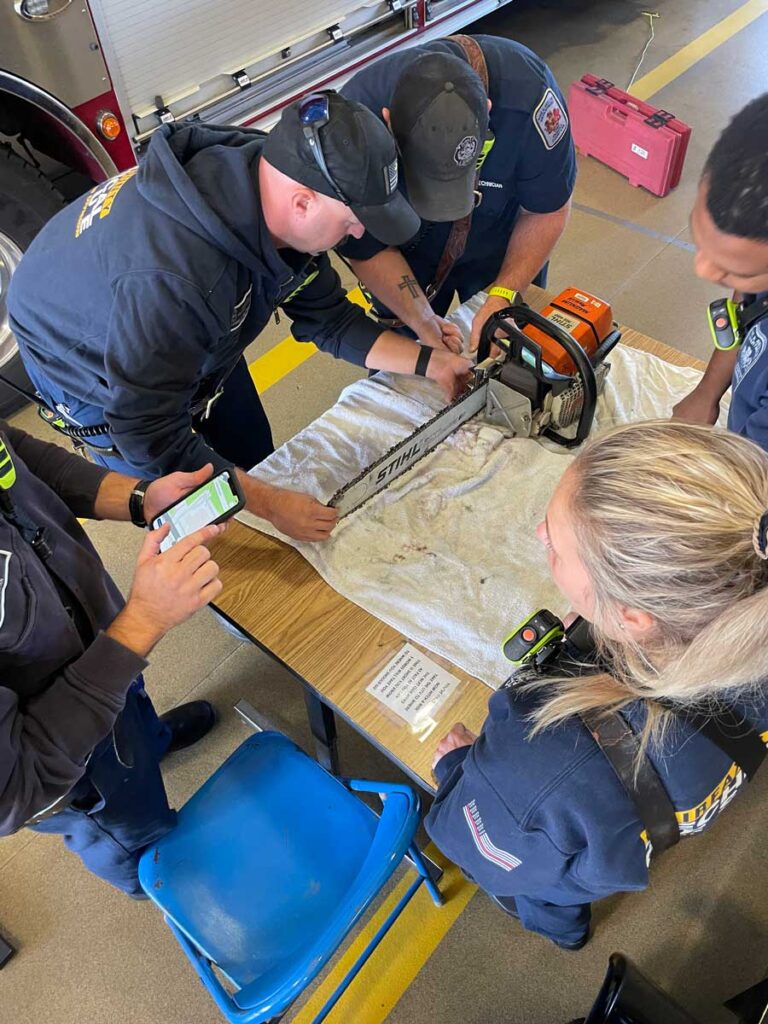 Firefighters work to reassemble chain saw