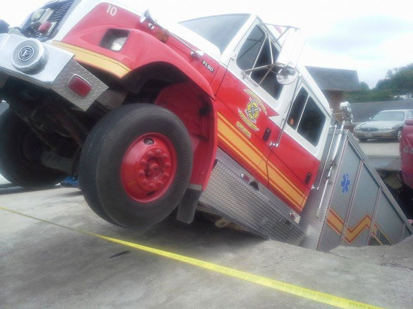 A fire apparatus falls into a hole during a collapse.