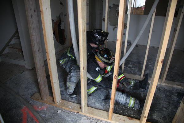 Crew member moving a down firefighter during an evolution at FDIC 2014.