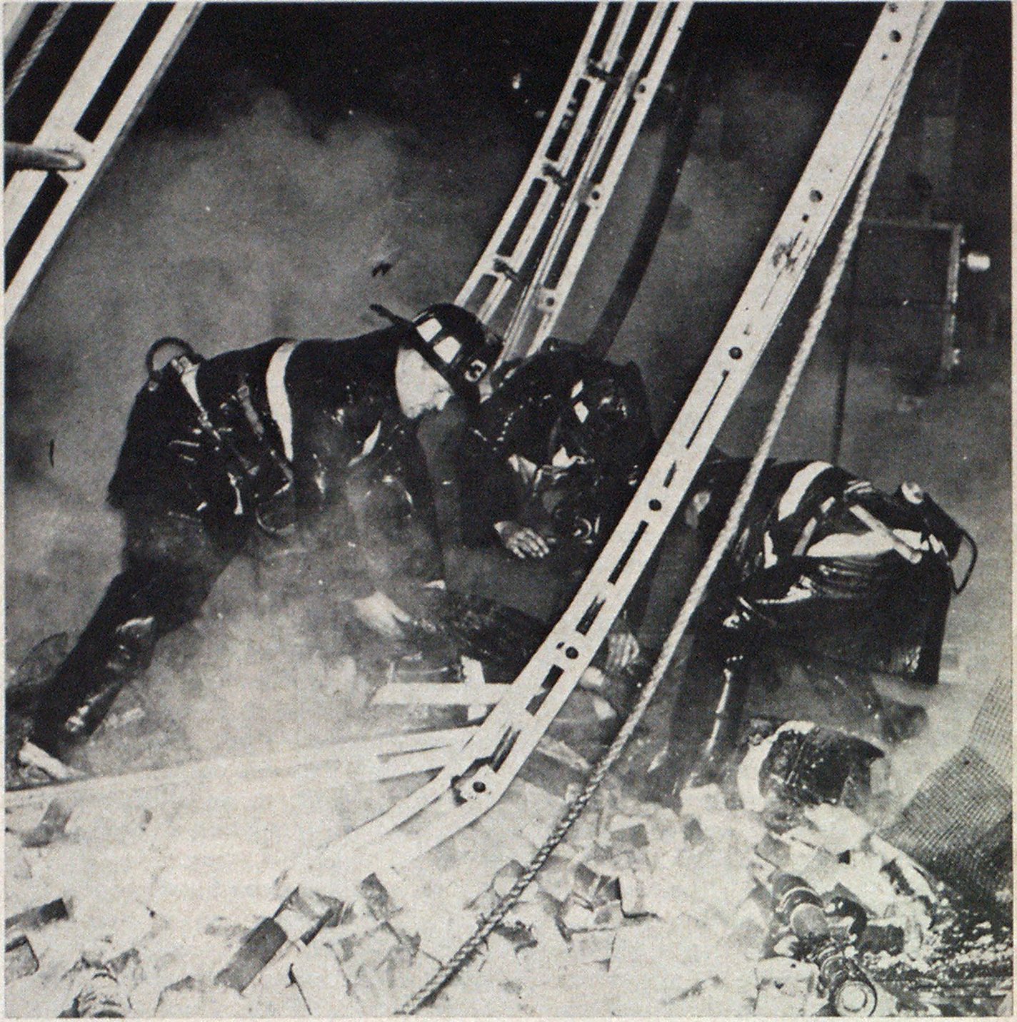 Smoke and dust cloud scene as three men dig into ruins to release fallen comrade